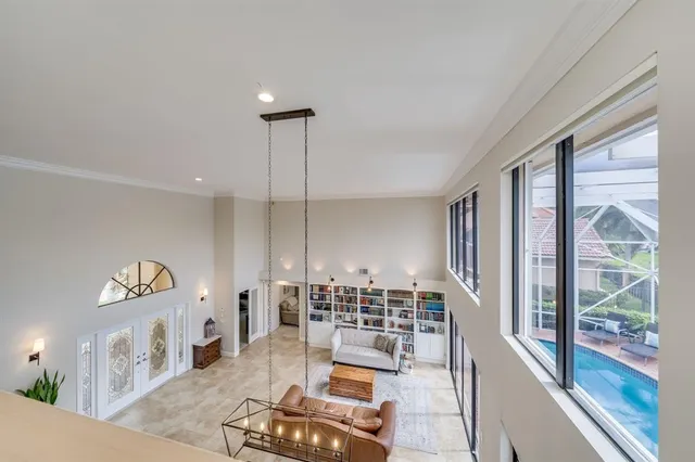 a living room with large windows and a table