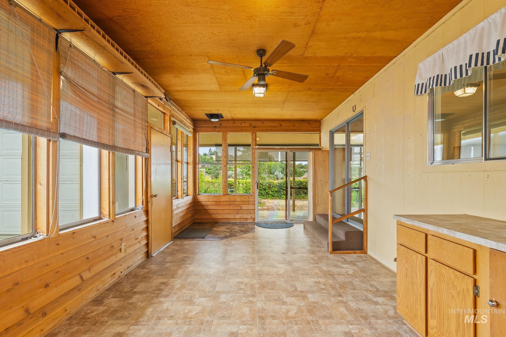1721 3rd Street Lewiston, ID 83501 - Photo 42 of 45 Enclosed sunroom featuring extensive window-lined walls, wood-paneled accents, and a ceiling fan