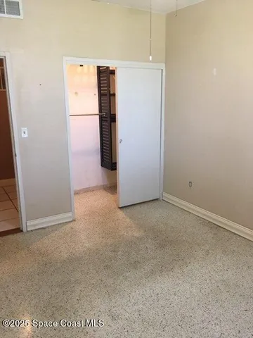 a view of a kitchen with refrigerator and white wall