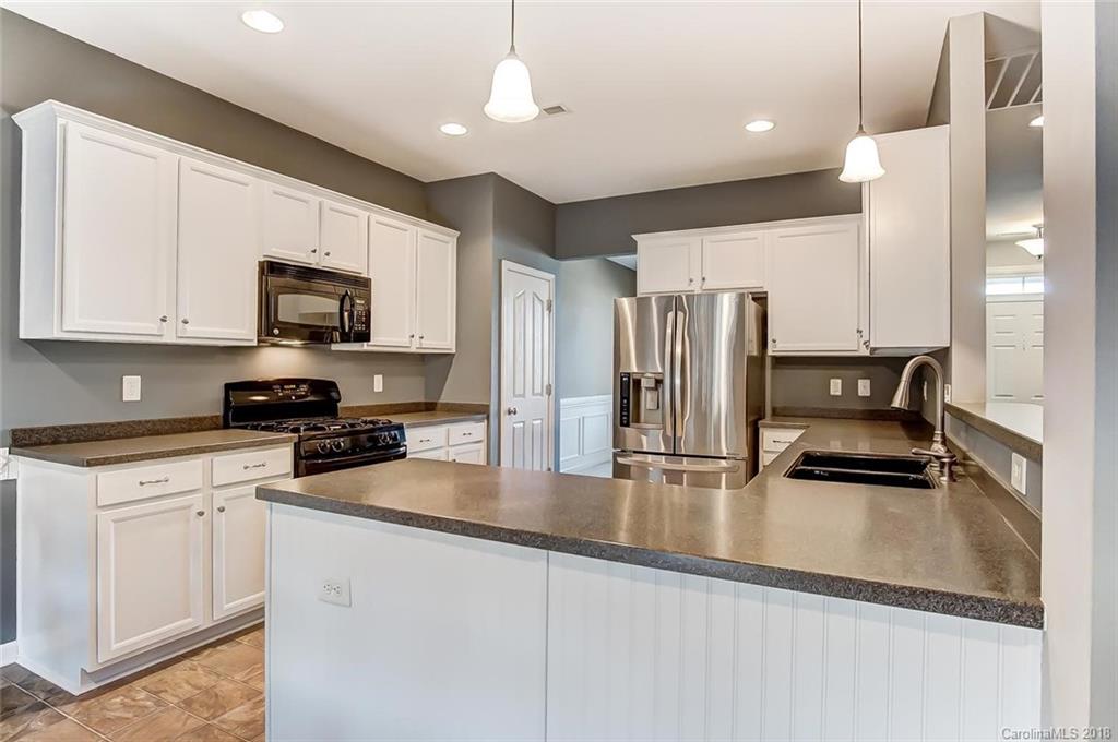 79297 Ridgehaven Road Lancaster, SC 29720 - Photo 11 of 36 a kitchen with stainless steel appliances granite countertop a refrigerator a stove a sink a stove and white cabinets with wooden floor