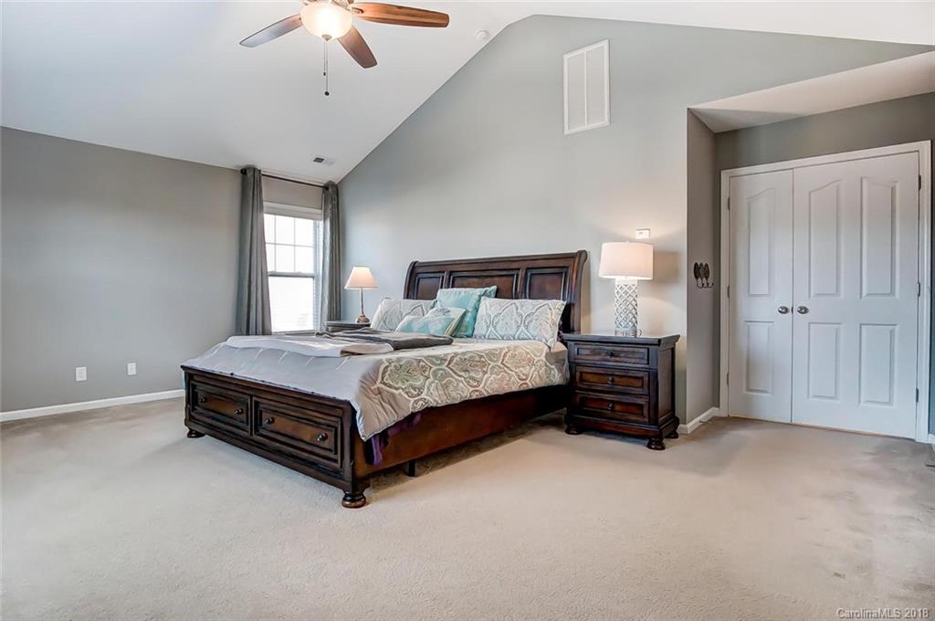 79297 Ridgehaven Road Lancaster, SC 29720 - Photo 23 of 36 a bed sitting in a spacious bedroom next to a window and a chandelier