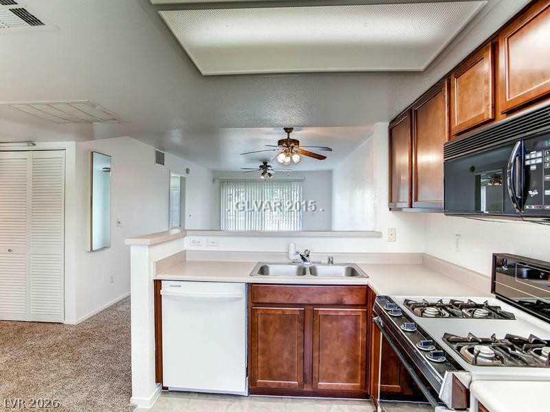 8070 West Russell Road, Unit 2120 Las Vegas, NV 89113 - Photo 7 of 11 A breakfast bar opens this well-equipped kitchen to the adjacent living area.