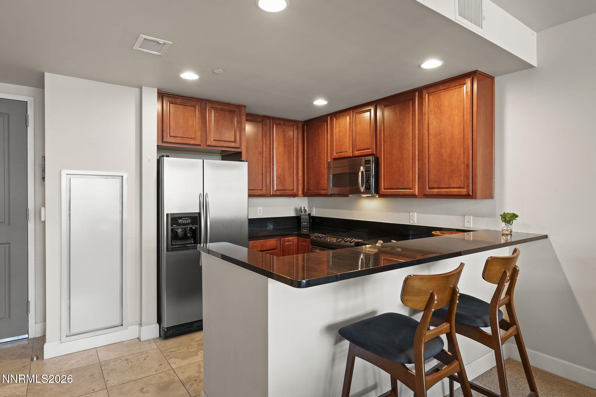 50 North Sierra Street, Unit 805 Reno, NV 89501 - Photo 9 of 23 a kitchen with granite countertop a refrigerator a sink a stove a microwave and island