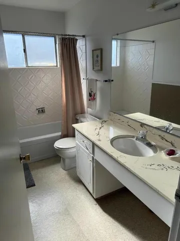 a bathroom with a granite countertop shower and a toilet
