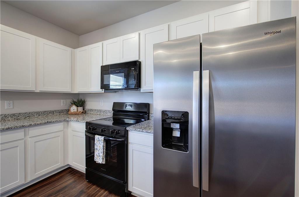509 Alma Street Cartersville, GA 30121 - Photo 12 of 39 a kitchen with stainless steel appliances granite countertop a refrigerator a stove and a sink with wooden floor