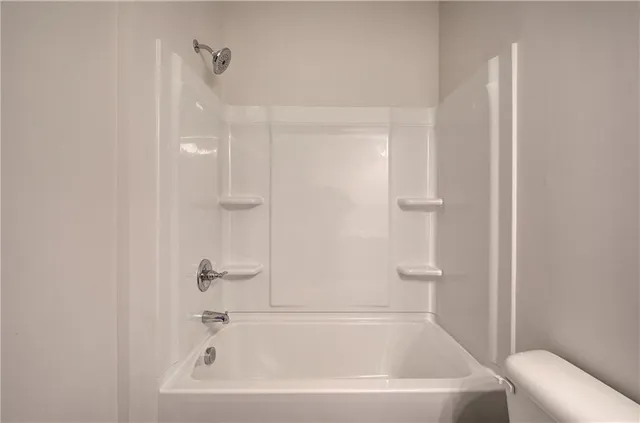 a white bath tub sitting next to a white toilet