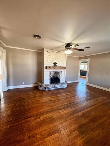 a view of empty room with wooden floor and fireplace