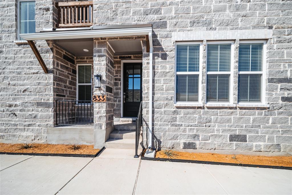 Doorway to property with stone siding and a balcony