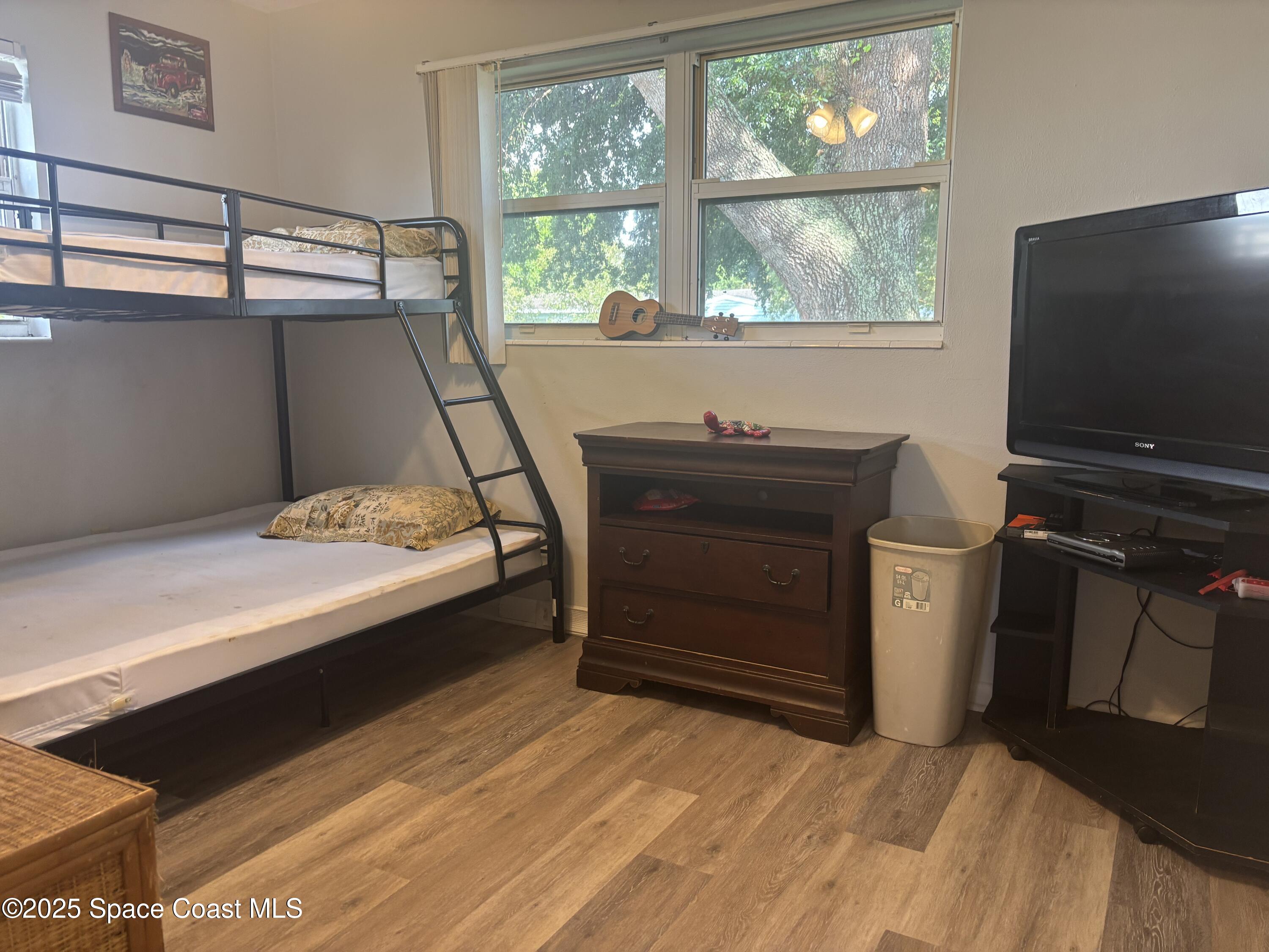 986 Macco Road Cocoa, FL 32927 - Photo 14 of 18 a bedroom with a bed and a flat tv screen on the dresser