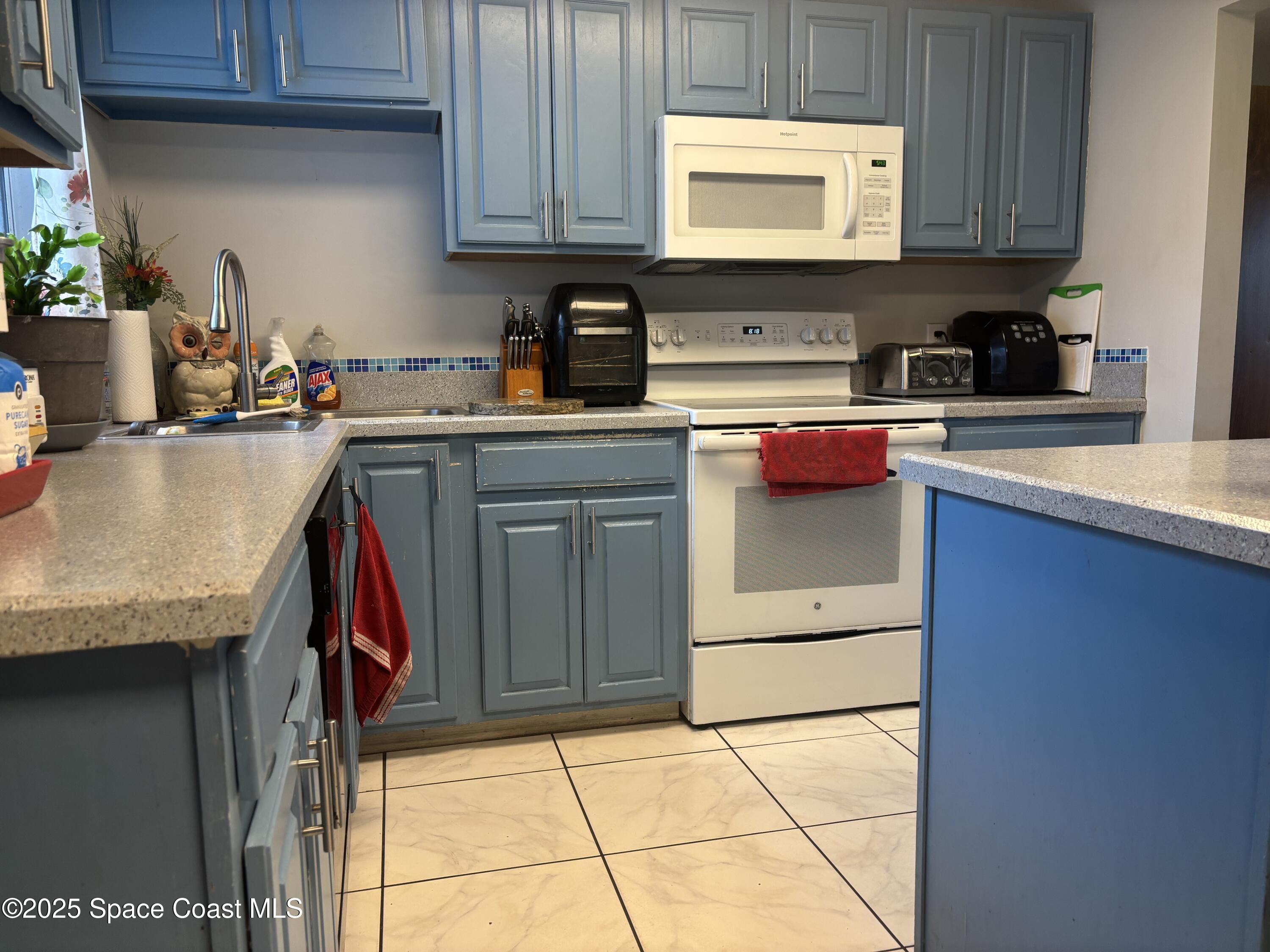 986 Macco Road Cocoa, FL 32927 - Photo 4 of 18 a kitchen with stainless steel appliances granite countertop a refrigerator sink and cabinets