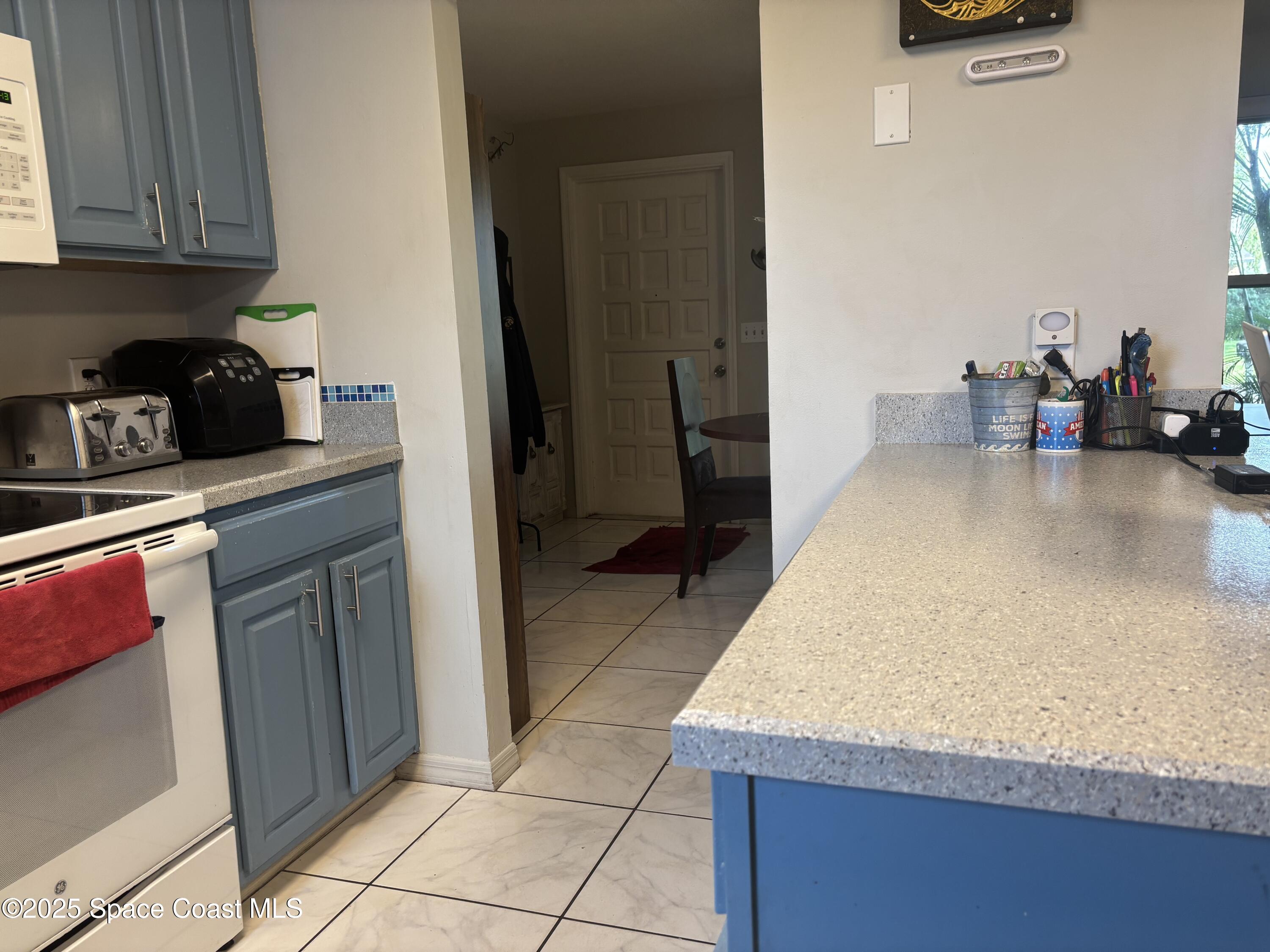 986 Macco Road Cocoa, FL 32927 - Photo 5 of 18 a kitchen with stainless steel appliances granite countertop a refrigerator and a stove