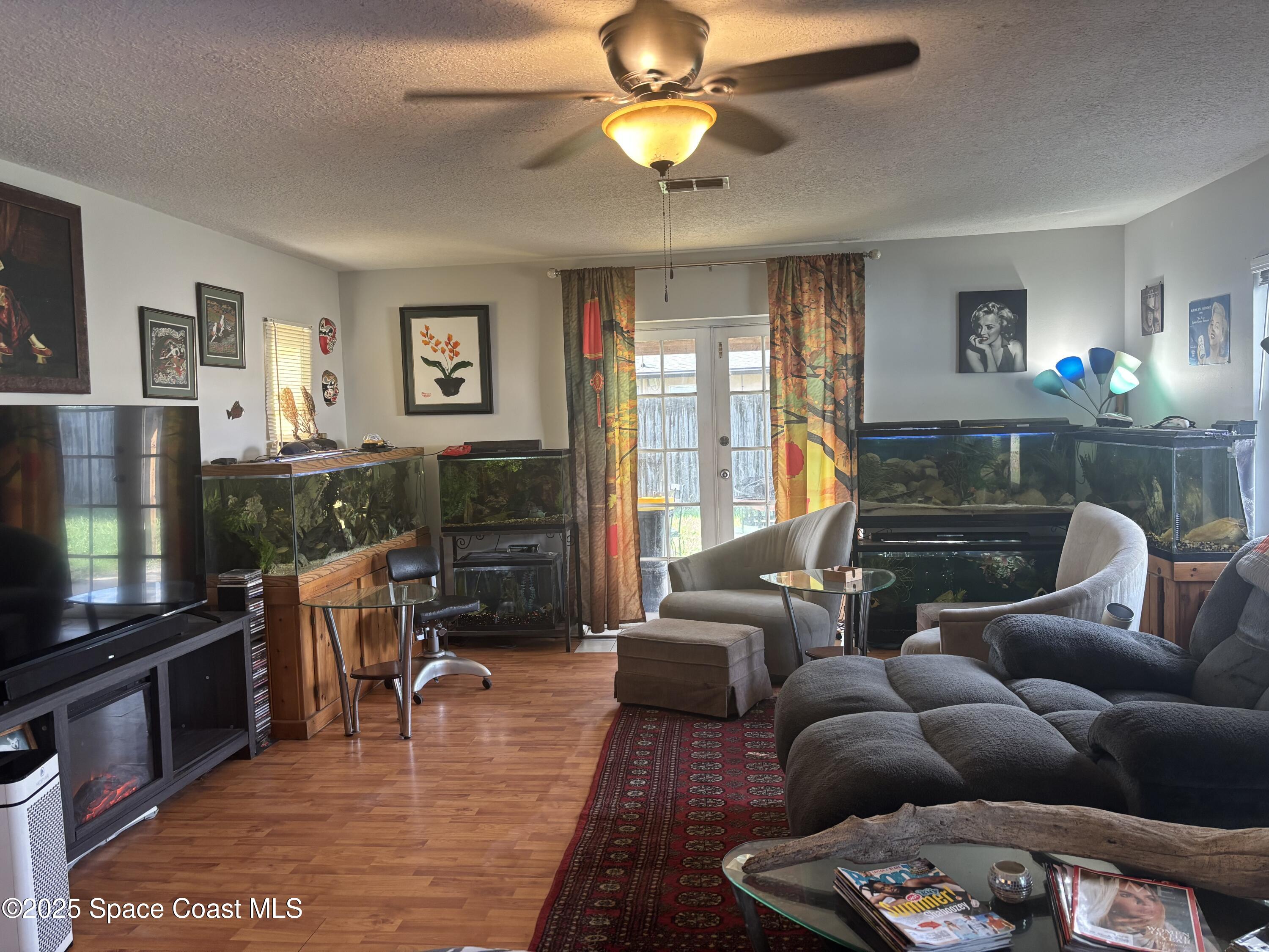 986 Macco Road Cocoa, FL 32927 - Photo 7 of 18 a living room with furniture a flat screen tv and a fireplace