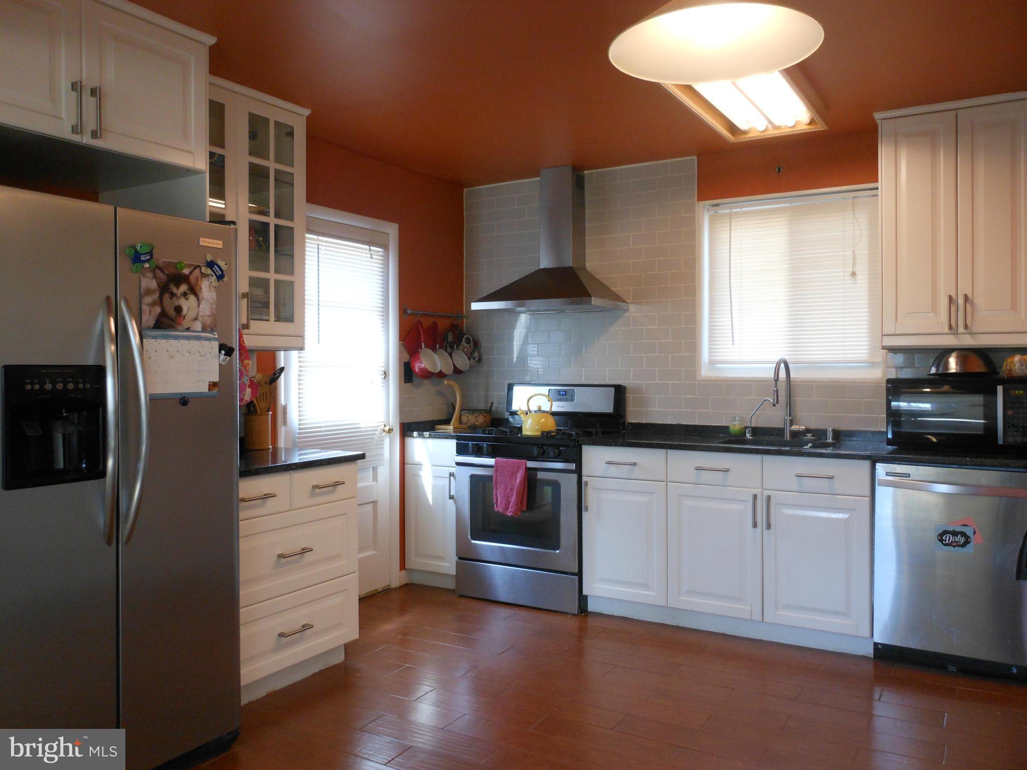 4306 Emden Street Silver Spring, MD 20906 - Photo 4 of 23 a kitchen with stainless steel appliances granite countertop a refrigerator a stove a sink and a microwave