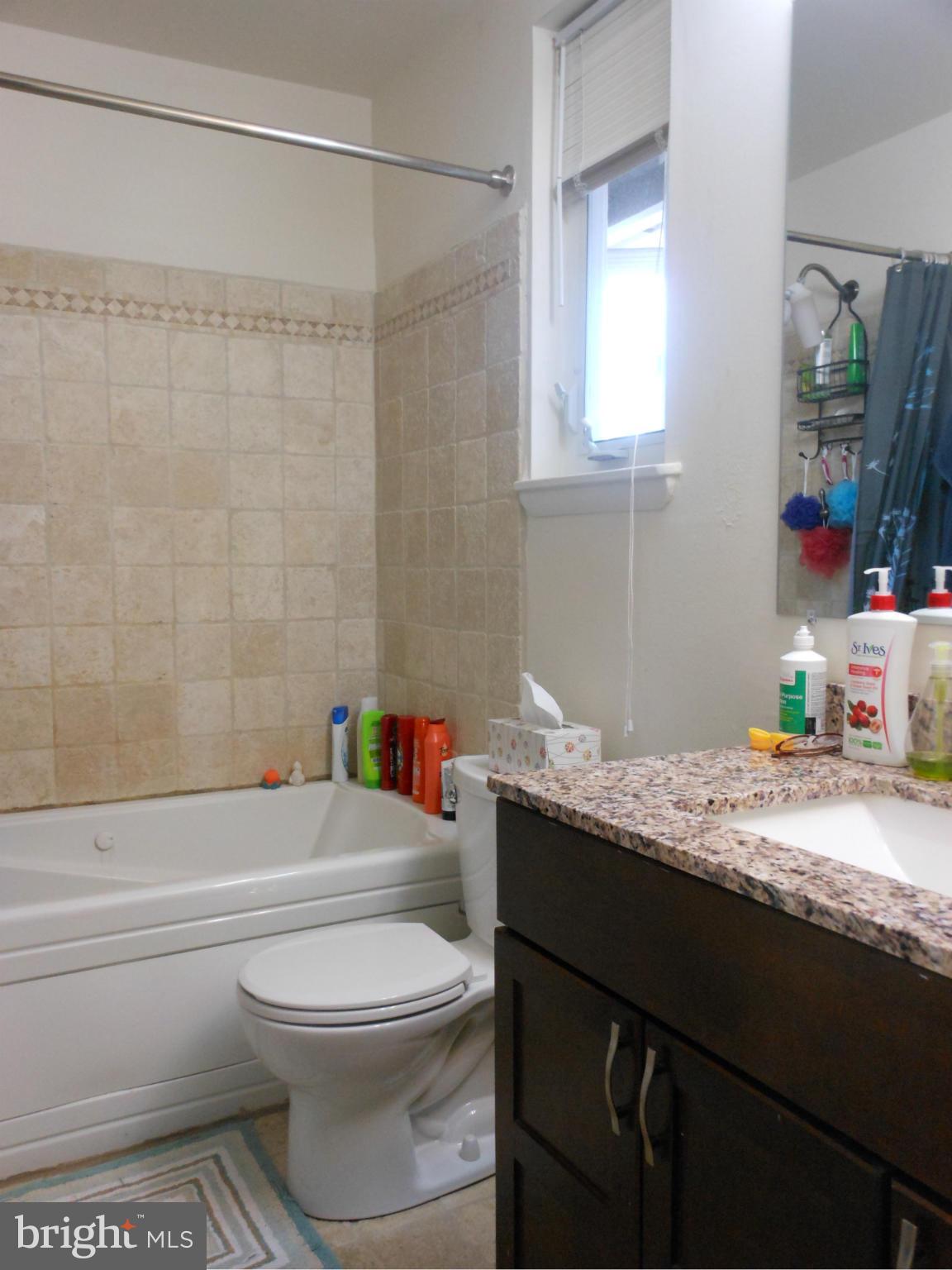 4306 Emden Street Silver Spring, MD 20906 - Photo 10 of 23 a bathroom with a granite countertop bathtub sink vanity mirror and toilet