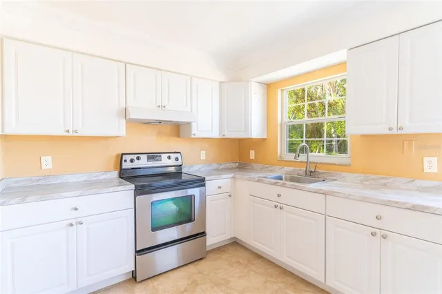 a kitchen with granite countertop white cabinets and a sink