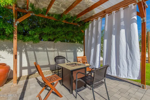a patio with table and chairs and potted plants