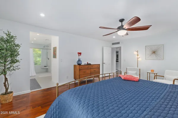 a bedroom with a bed and wooden floor