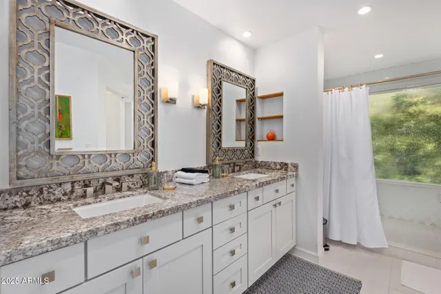 a bathroom with a granite countertop sink double vanity and a mirror