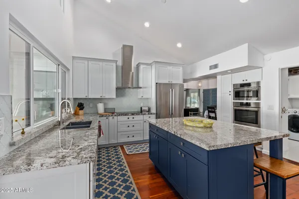 a kitchen with stainless steel appliances granite countertop a sink stove and refrigerator