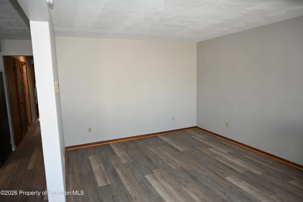 a view of an empty room with wooden floor