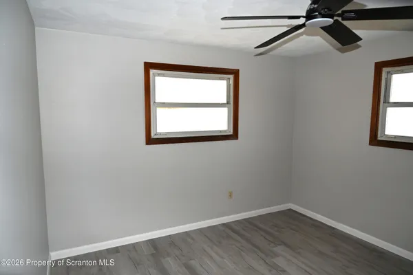 an empty room with a window and a ceiling fan