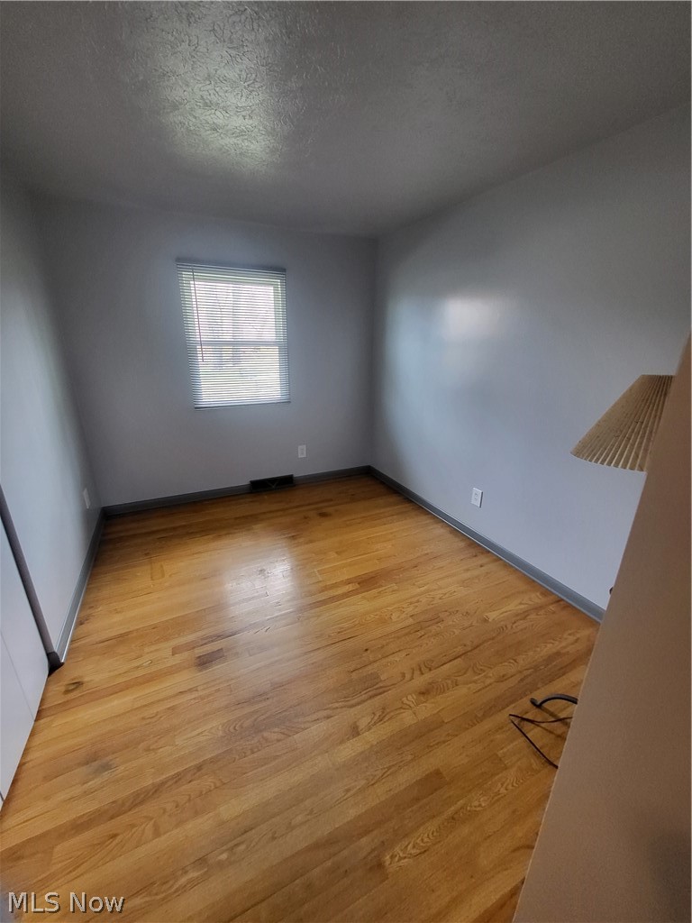 3260 Mogadore Road Akron, OH 44312 - Photo 10 of 20 Spare room featuring light hardwood / wood-style flooring and a textured ceiling