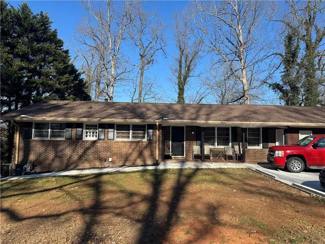a front view of a house with patio swimming pool and red chairs
