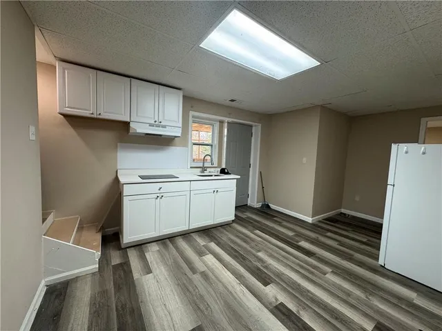 a kitchen with a sink a refrigerator and cabinets