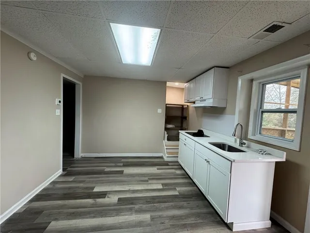 a kitchen with granite countertop a sink and cabinets