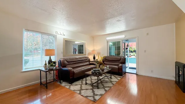 a living room with furniture and a wooden floor