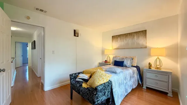 a bedroom with a bed and wooden floor