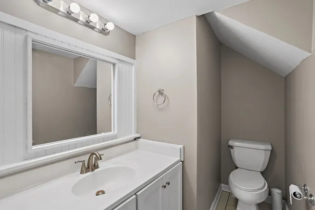 a bathroom with a toilet sink vanity and mirror