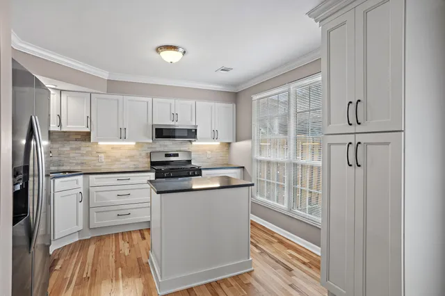a kitchen with white cabinets and stainless steel appliances