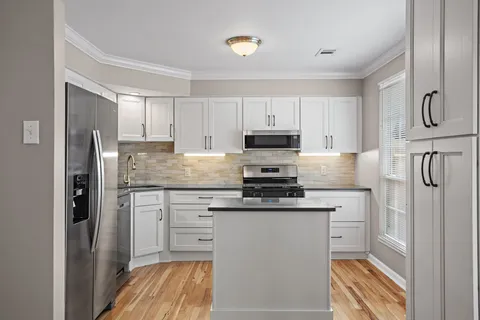 a kitchen with stainless steel appliances granite countertop a refrigerator sink and stove
