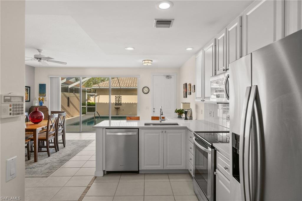 6072 Towncenter Circle Naples, FL 34119 - Photo 10 of 45 a kitchen with stainless steel appliances granite countertop a refrigerator and a sink