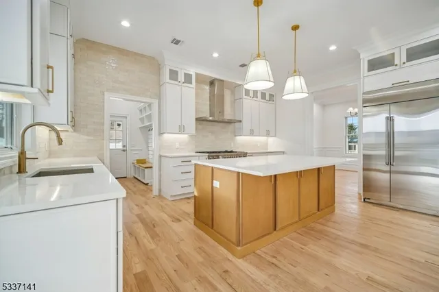 a kitchen with stainless steel appliances granite countertop a sink a stove and a refrigerator