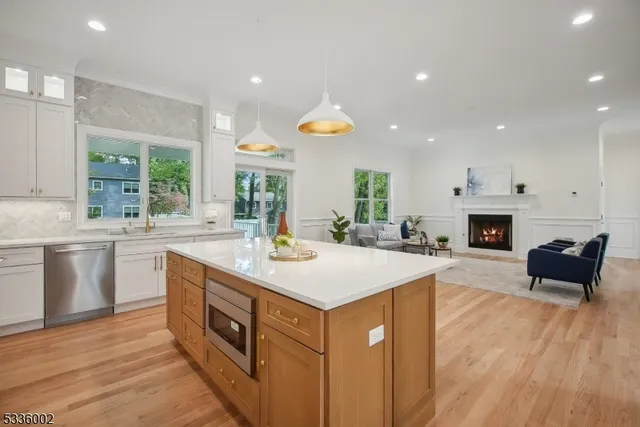 a kitchen with a stove a sink and a refrigerator with white cabinets