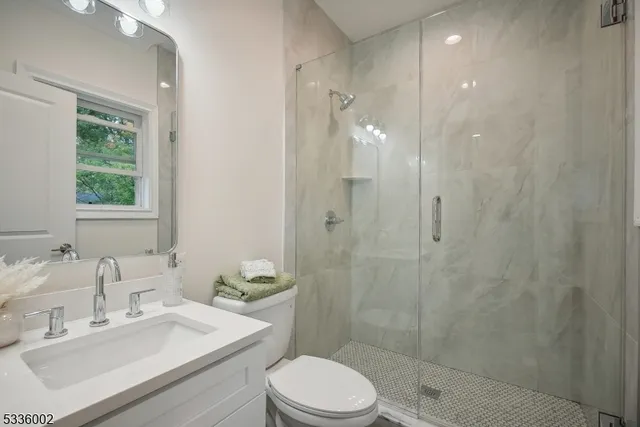 a bathroom with a sink toilet a mirror and shower