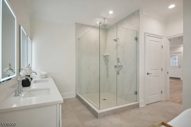 a bathroom with a shower sink and mirror