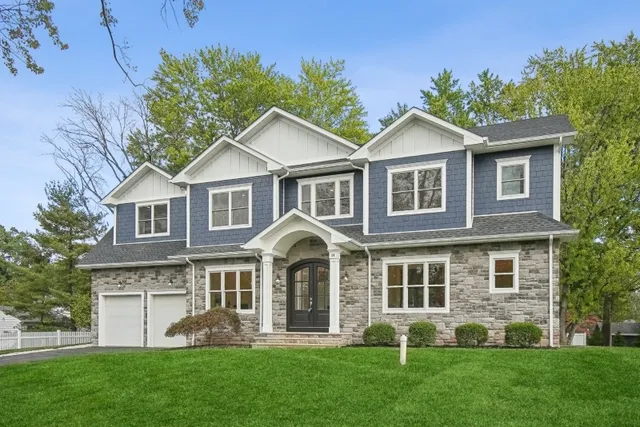 a front view of a house with a yard and green space
