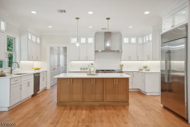 a large kitchen with cabinets wooden floor and stainless steel appliances
