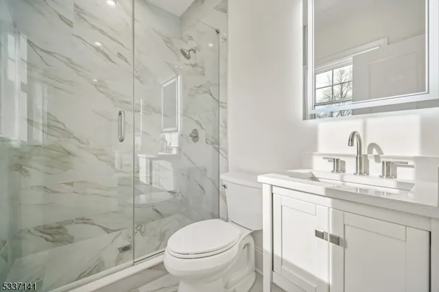 a bathroom with a granite countertop sink toilet and shower