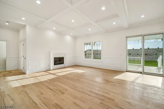 a view of an empty room with a window and a fireplace