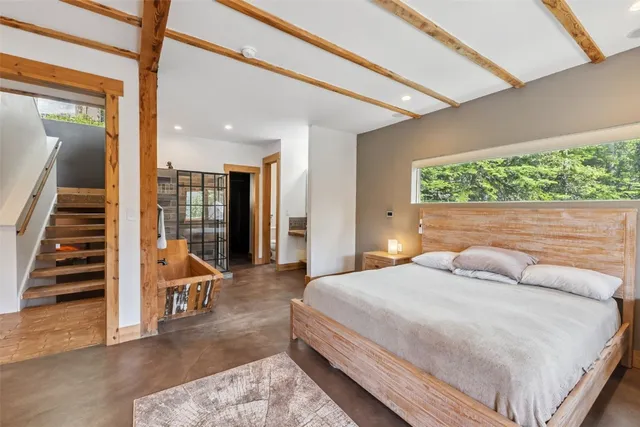 a bedroom with a large bed and a large window with outer view