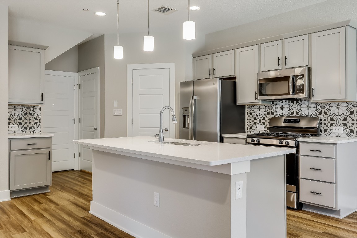 a kitchen with white cabinets and stainless steel appliances