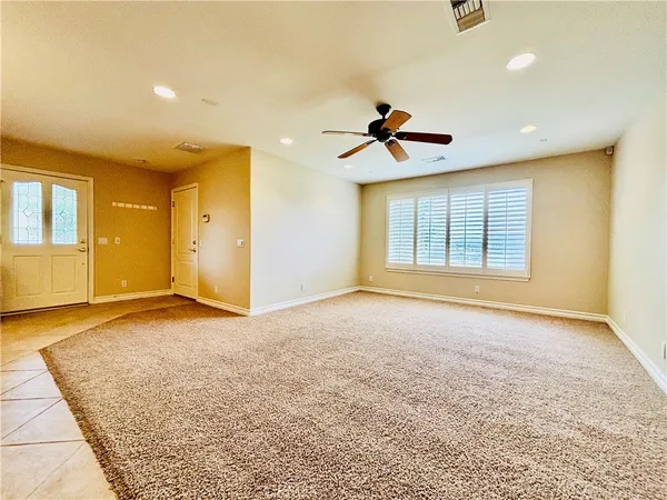 a view of an empty room with a window and a kitchen