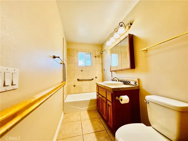 a bathroom with a granite countertop toilet sink and mirror