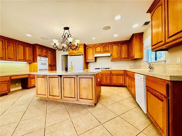 a kitchen with stainless steel appliances granite countertop a stove a sink and a refrigerator