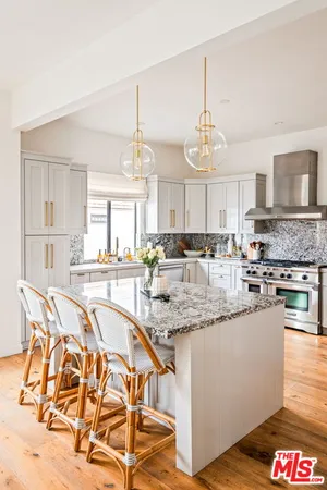 a kitchen with stainless steel appliances granite countertop a stove and white cabinets