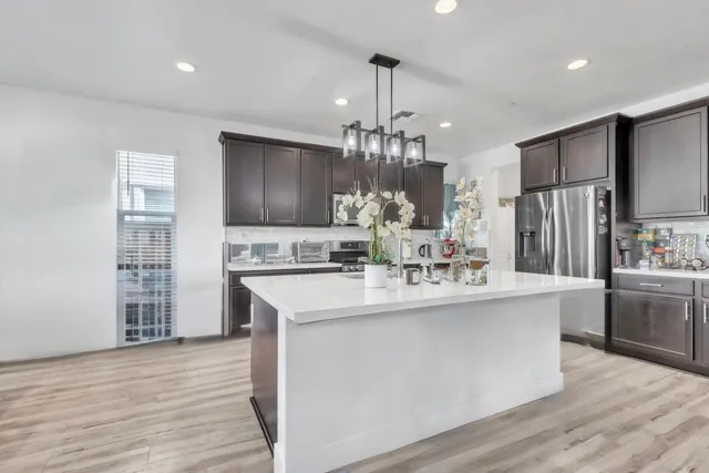 a kitchen with kitchen island stainless steel appliances a sink stove and refrigerator